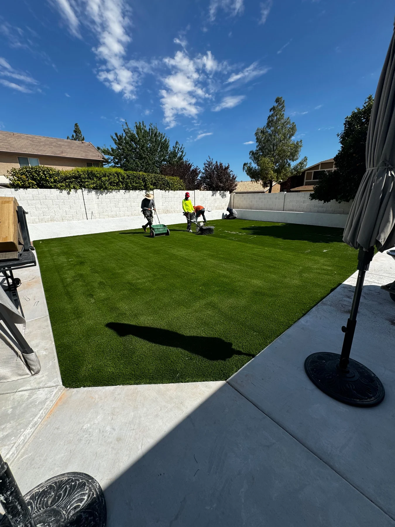 Sunlit ENC backyard patio alongside a green lawn