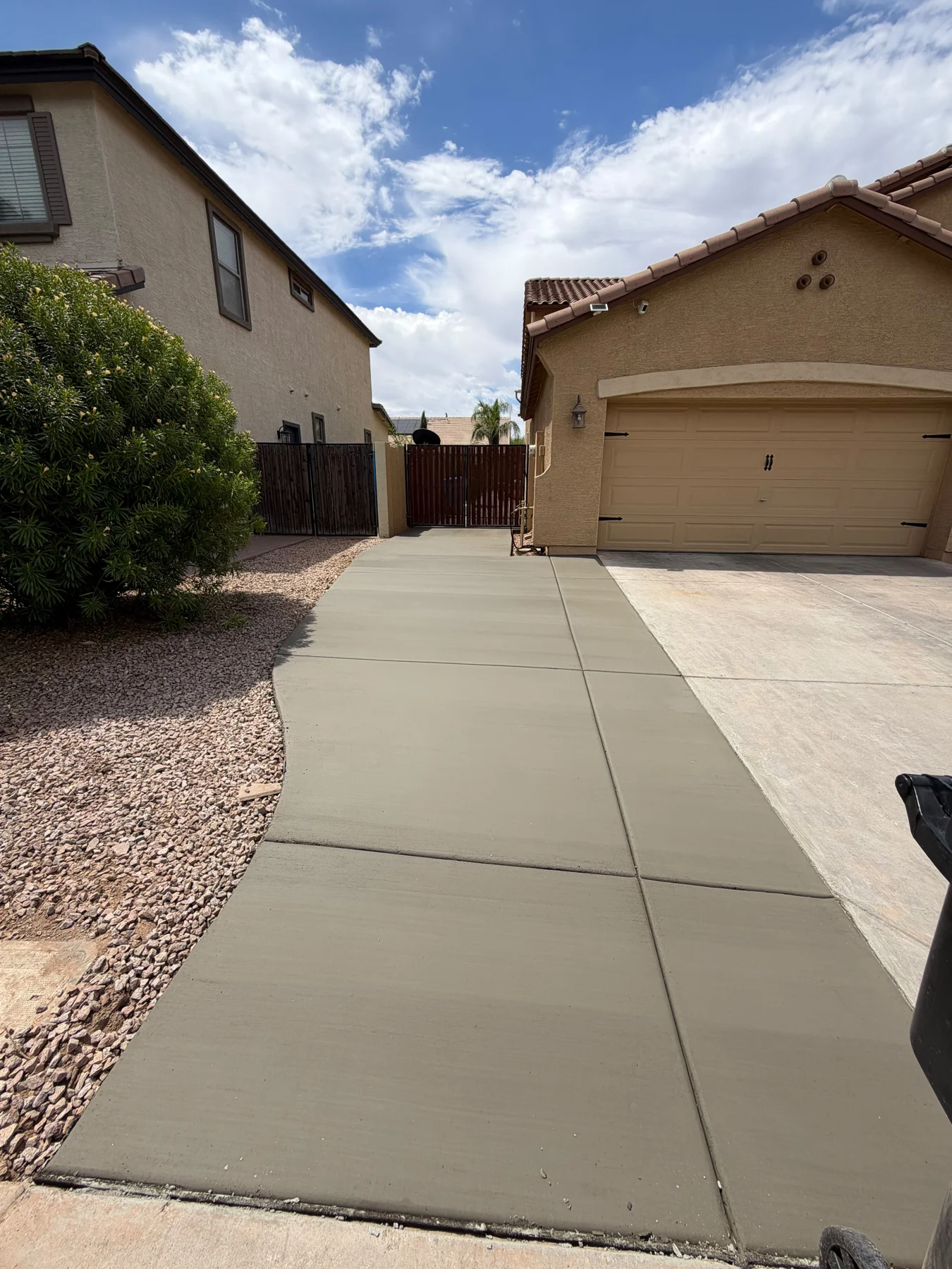Concrete side yard path between an Arizona house and boundary wall